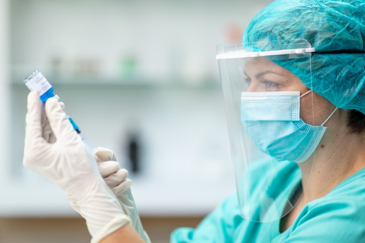 nurse holding vial of covid-19 vaccine brings hope