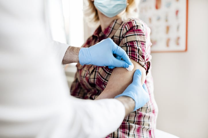 Medicine, Vaccination and Healthcare Concept - Senior Women Wearing Face Protective Medical Mask for Protection From Virus Disease Doing Injection of Vaccine