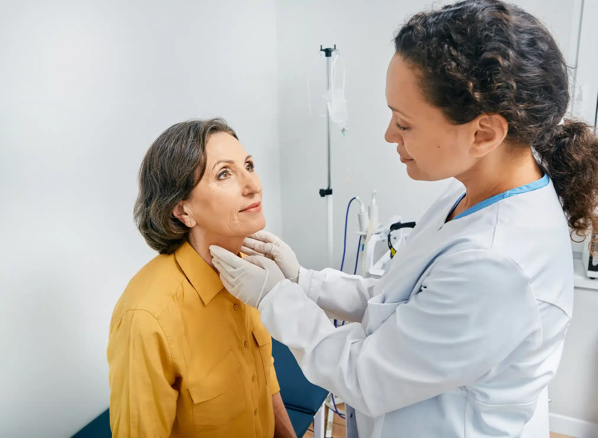 doctor checking patient for thyroid issues