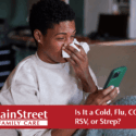 Person sneezing on their couch while looking at their cell phone. Featured image for Is It a Cold, Flu, COVID, RSV, or Strep? blog post